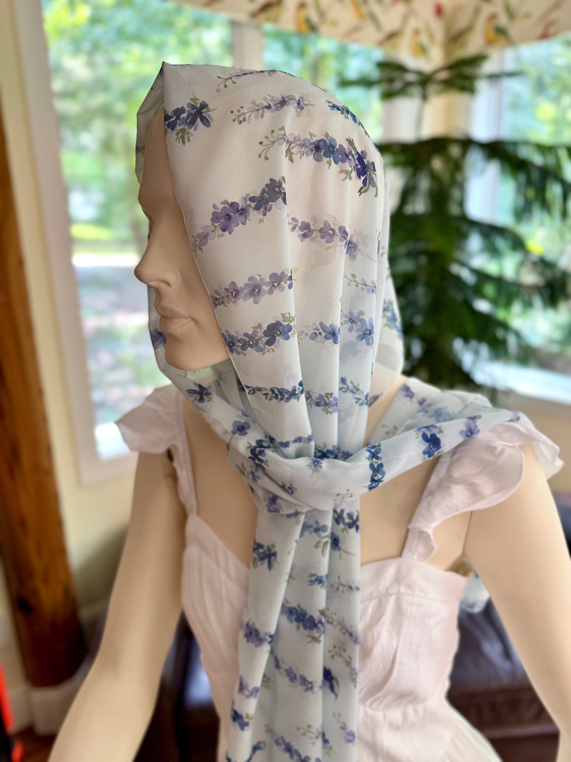 Person wearing a floral headscarf with a blurred background