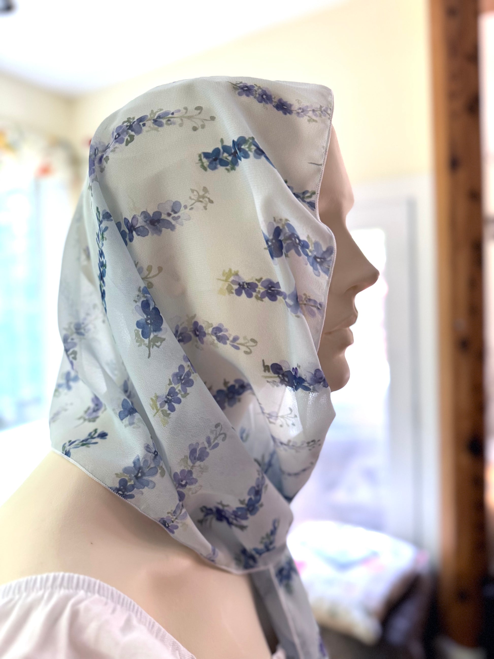 Person wearing a floral headscarf with a blurred background